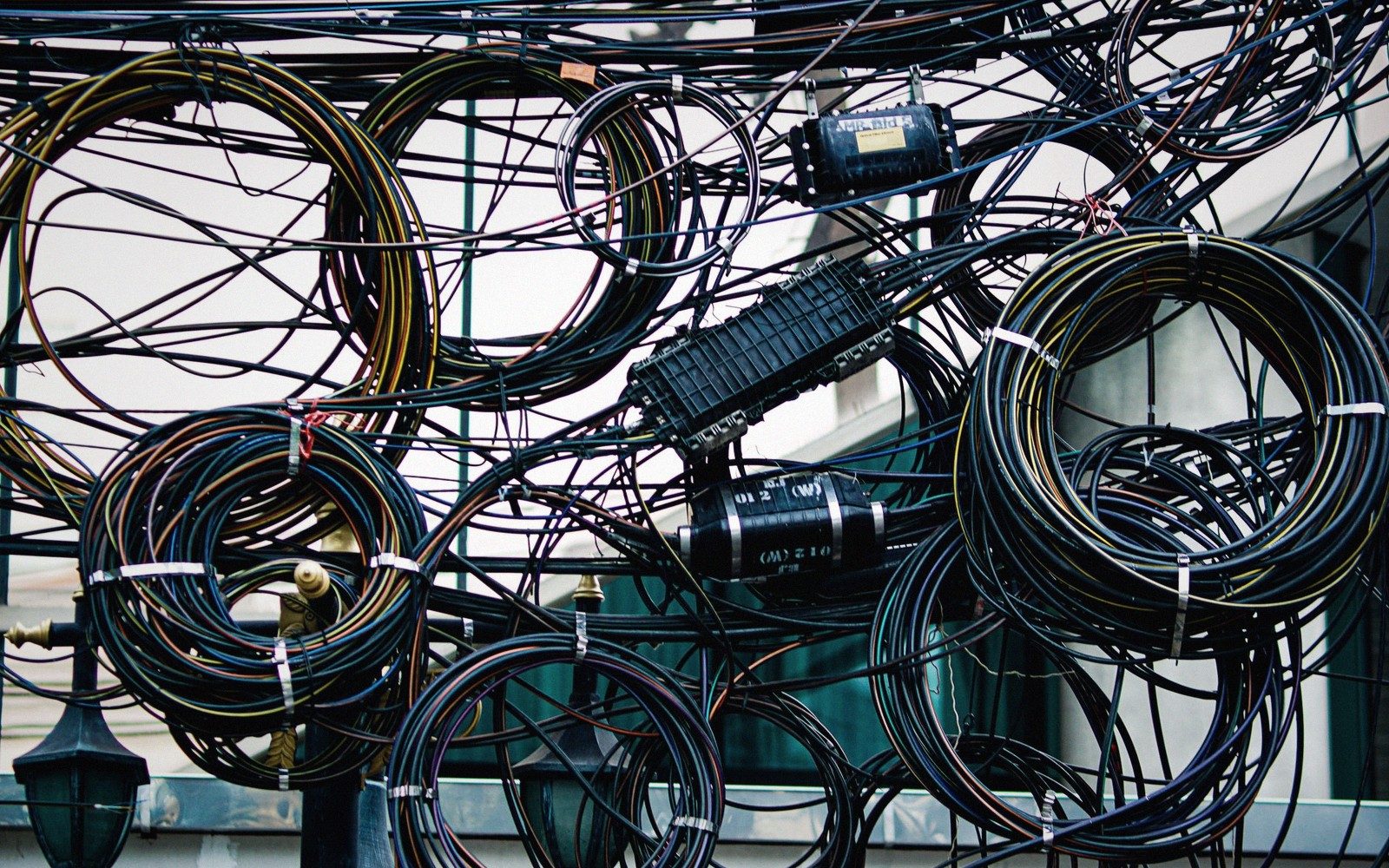 a stack of external drives and coiled cables on a desk